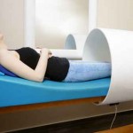 Patient macht pulsierende Magnetfeldtherapie bei Arzt in Behandl